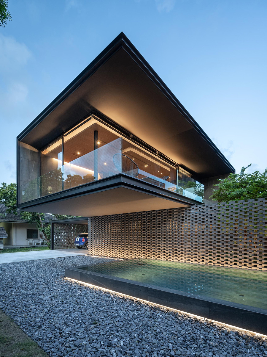 Cantilevered glass villa exterior with reflecting pool