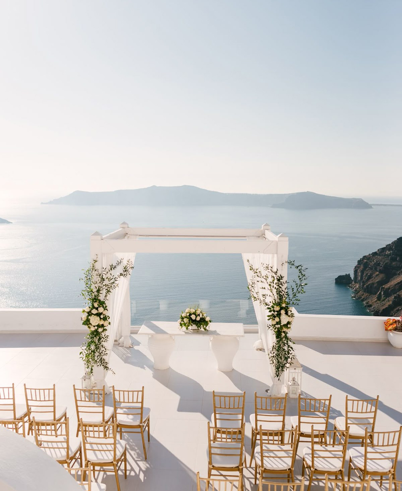 Ceremony arch dressed with white flowers overlooking the sea