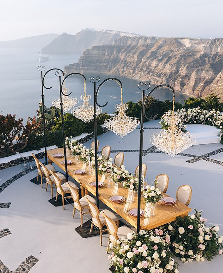 Long banquet table with chandeliers set above the caldera