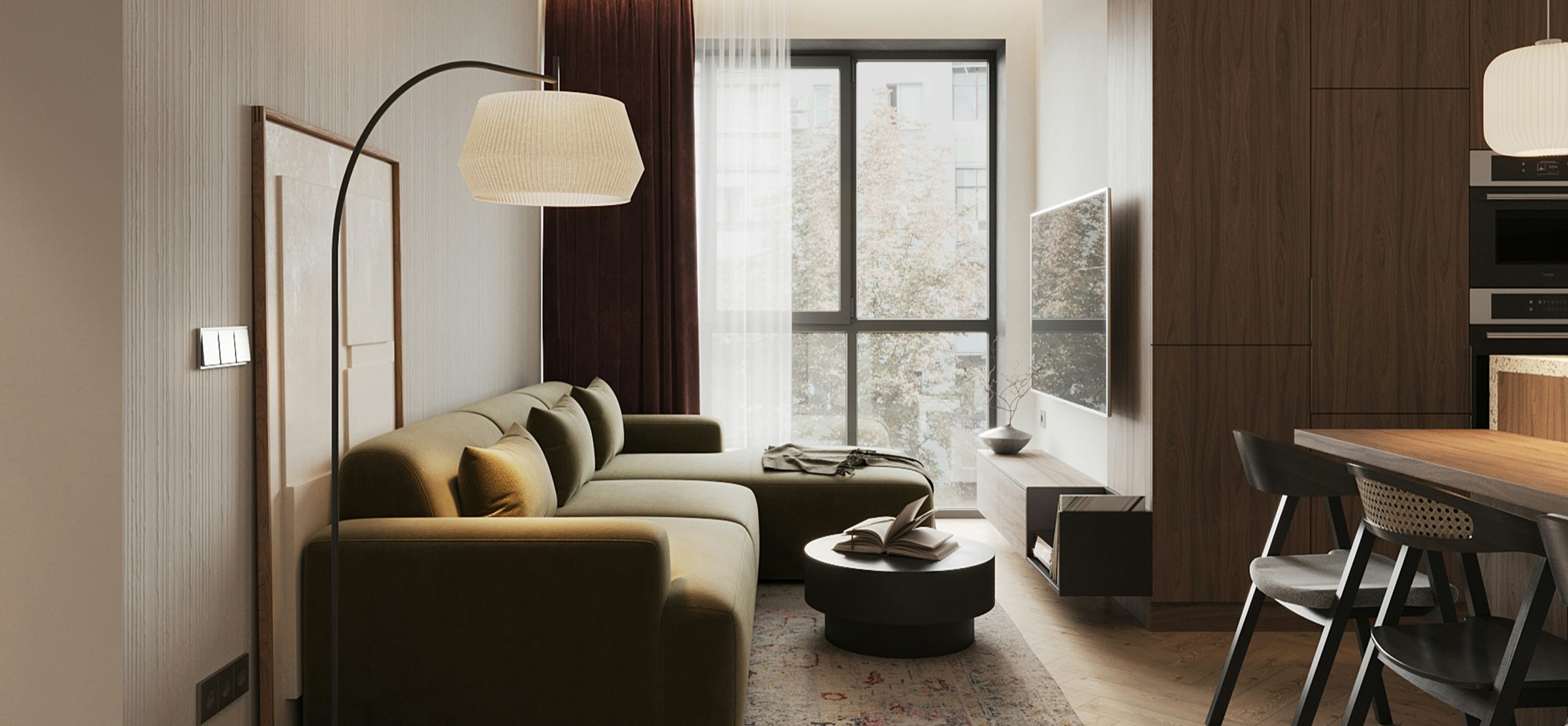 An open-plan living room with an olive sofa, a floor lamp and a dining table by the window
