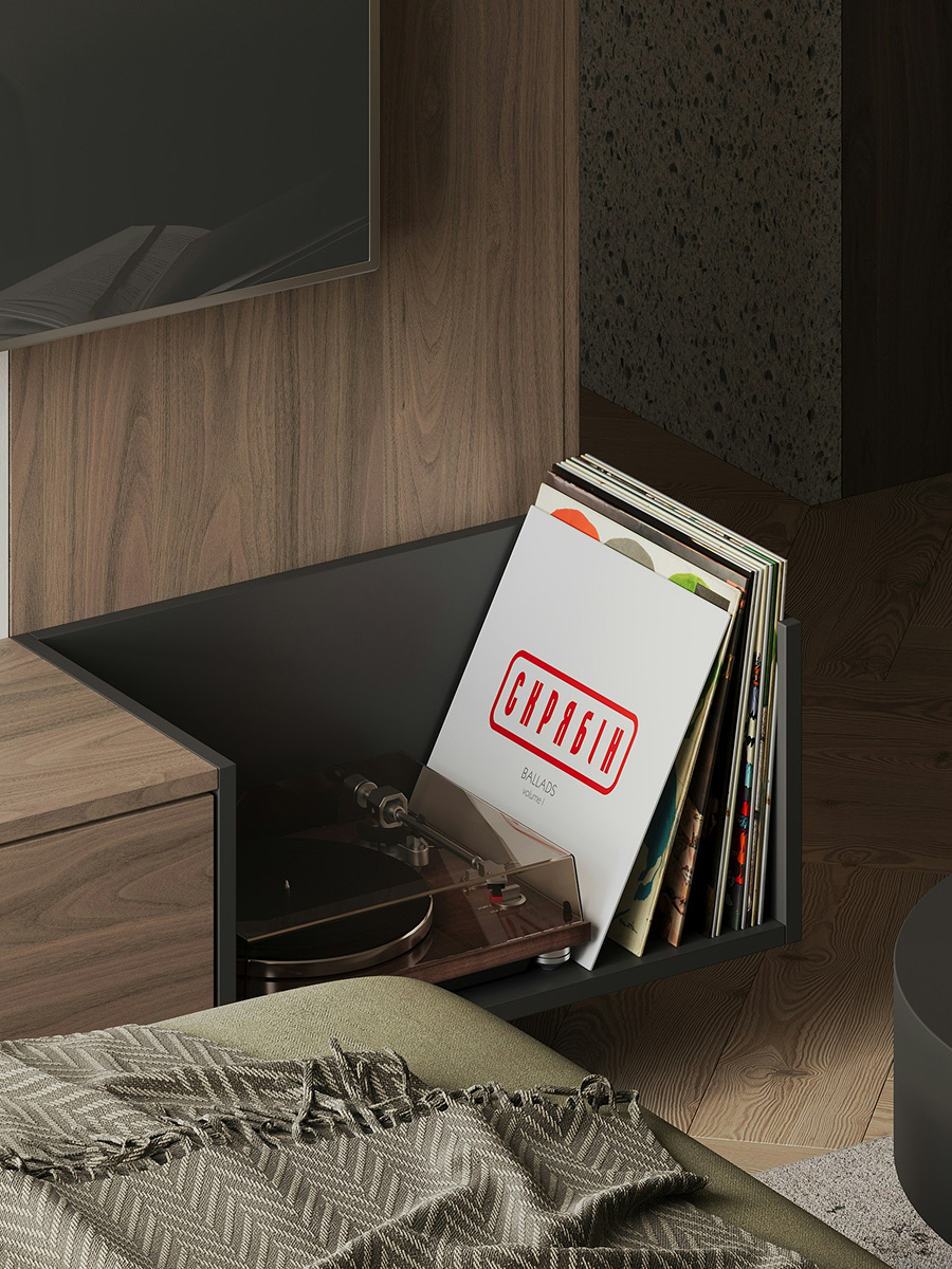 Records leaning against a walnut sideboard beside a throw-covered sofa